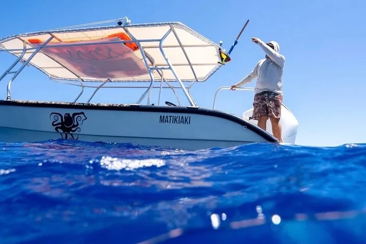 Guide standing on the bow of the Aimeho boat Matikiaki on the open ocean